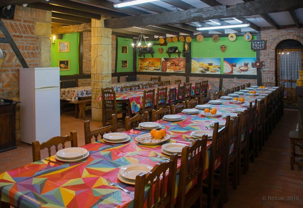 Salón principal de Finca Gándara con vigas de madera y mesas preparadas